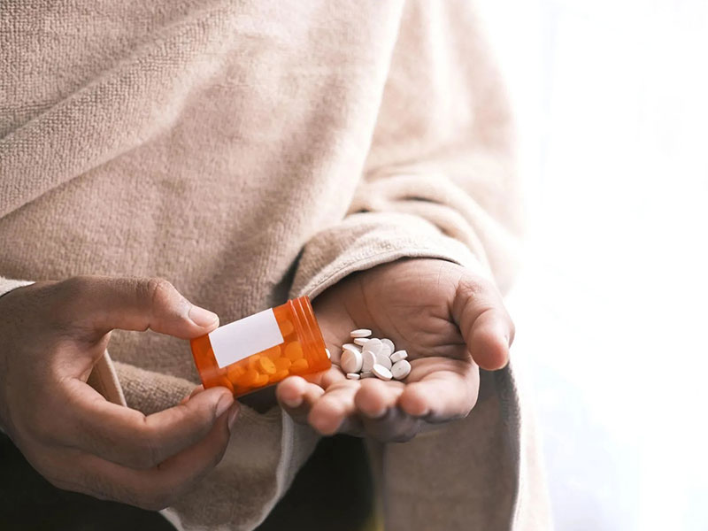 hand holding a bottle of pills